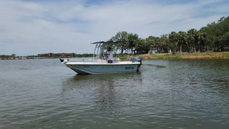 Slide: The Image of 2011 Carolina Skiff 178 DLV boat on calm lake with trees in background. - 2