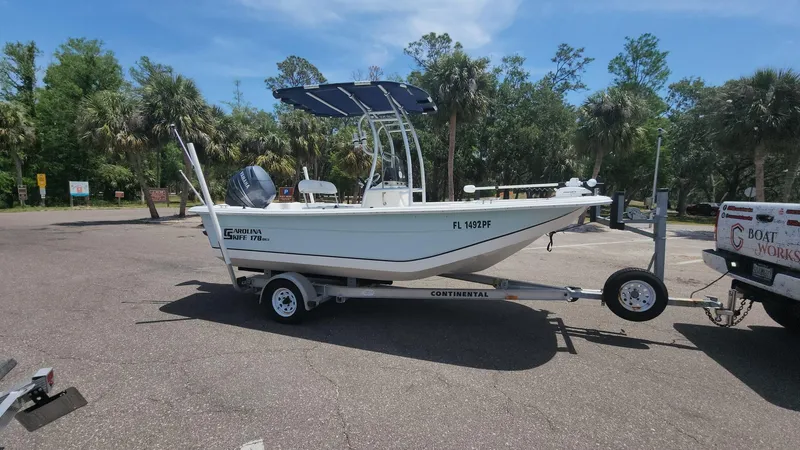 Slide: The Image of 2011 Carolina Skiff 178 DLV boat on trailer in sunny parking lot. - 23