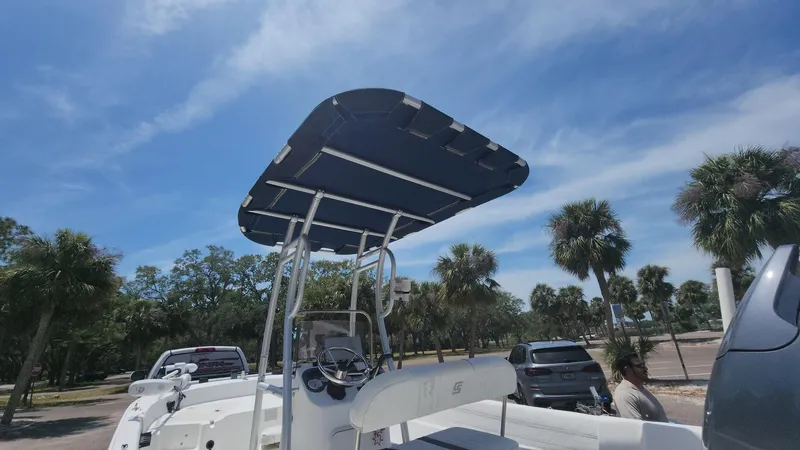 Slide: The Image of 2011 Carolina Skiff 178 DLV boat with canopy, parked under a clear blue sky. - 32