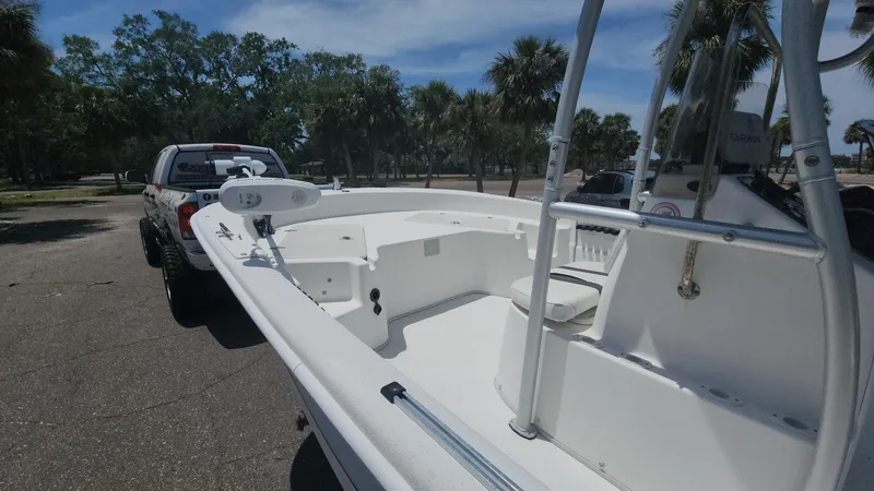 Slide: The Image of 2011 Carolina Skiff 178 DLV boat on trailer, parked outdoors with trees in background. - 34