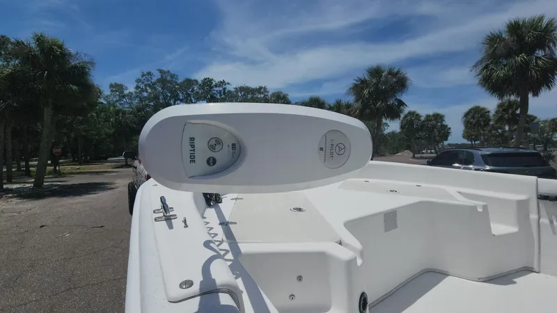 Slide: The Image of 2011 Carolina Skiff 178 DLV boat with trolling motor, parked near palm trees under blue sky. - 35