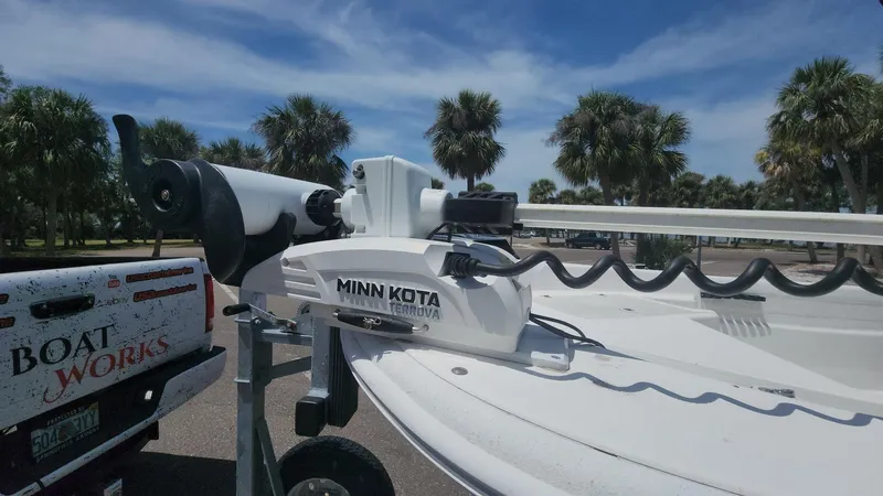 Slide: The Image of 2011 Carolina Skiff 178 DLV with Minn Kota trolling motor, parked near palm trees. - 36
