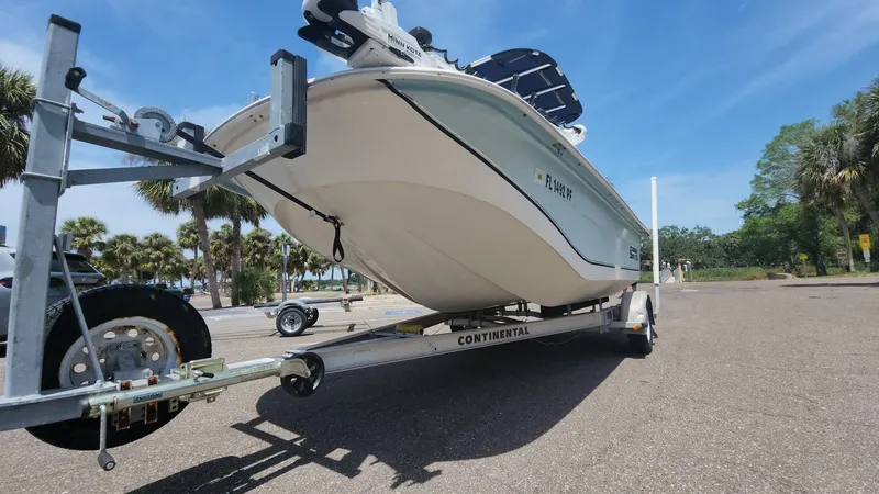 Slide: The Image of 2011 Carolina Skiff 178 DLV boat on trailer, parked outdoors under clear blue sky. - 40