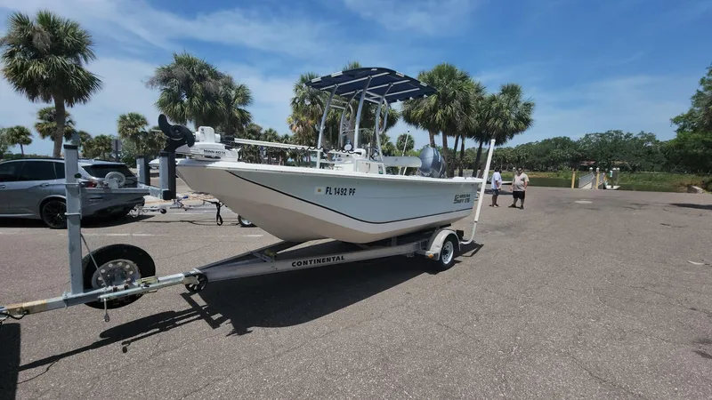 Slide: The Image of 2011 Carolina Skiff 178 DLV boat on trailer in sunny parking lot with palm trees. - 43
