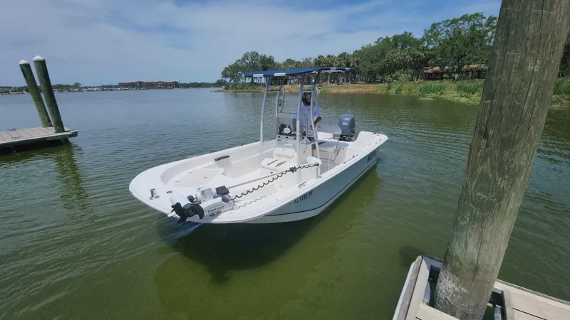 Slide: The Image of 2011 Carolina Skiff 178 DLV boat docked on calm water under a clear sky. - 44