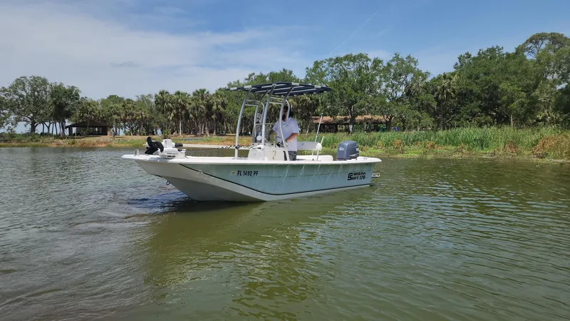 Slide: The Image of 2011 Carolina Skiff 178 DLV boat cruising on a calm river with lush greenery. - 46