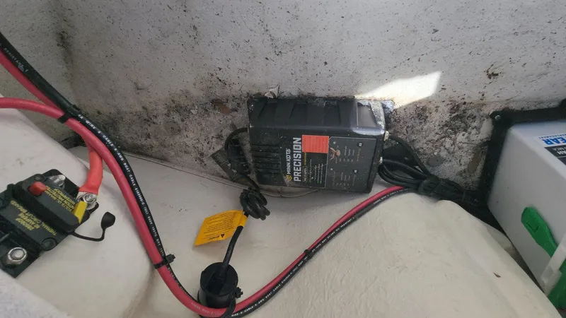 Slide: The Image of Battery compartment of a 2011 Carolina Skiff 178 DLV with wiring and charger. - 6