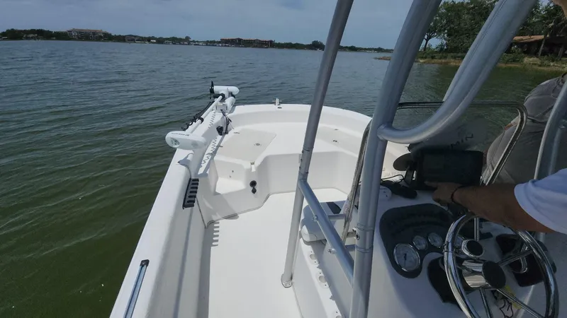 Slide: The Image of 2011 Carolina Skiff 178 DLV boat on calm lake waters, featuring a sleek white deck. - 8