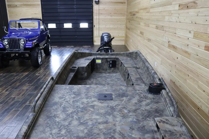 Slide: The Image of 2025 Excel 1751 Viper F4 boat in a wooden garage with a blue Jeep. - 9