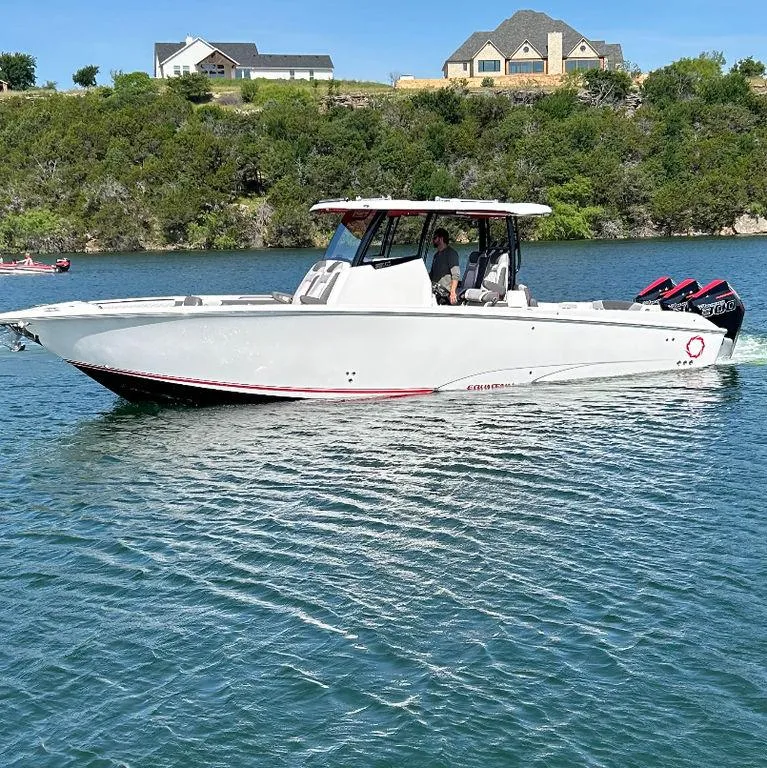 Slide: The Image of 2024 Fountain 32 NX boat cruising on a lake with scenic background. - 1