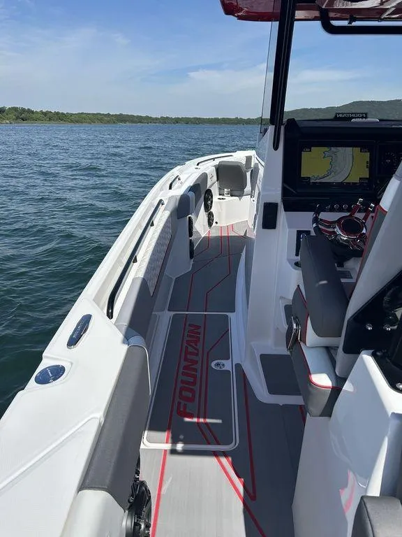 Slide: The Image of 2024 Fountain 32 NX boat interior with advanced navigation system on a calm lake. - 16