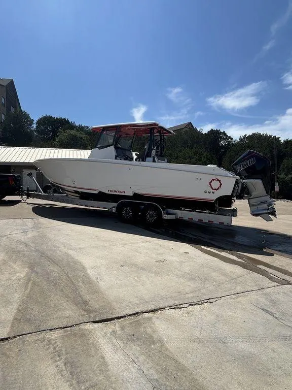 Slide: The Image of 2024 Fountain 32 NX boat on a trailer in a parking lot. - 19