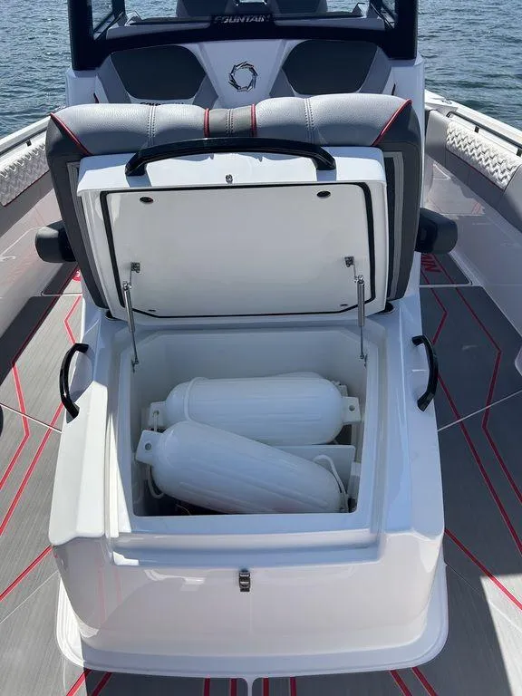 Slide: The Image of 2024 Fountain 32 NX boat with open storage compartment and fenders. - 5