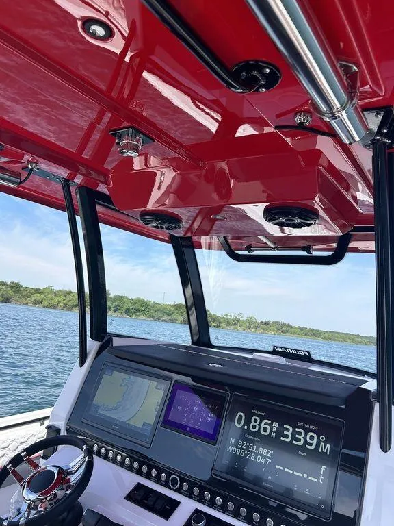 Slide: The Image of 2024 Fountain 32 NX boat dashboard with navigation screens and red canopy. - 8