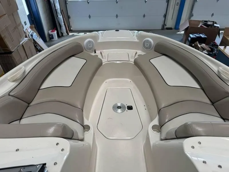 Slide: The Image of 2004 Sea Ray 240 Sundeck boat interior with beige seating and storage compartments. - 11