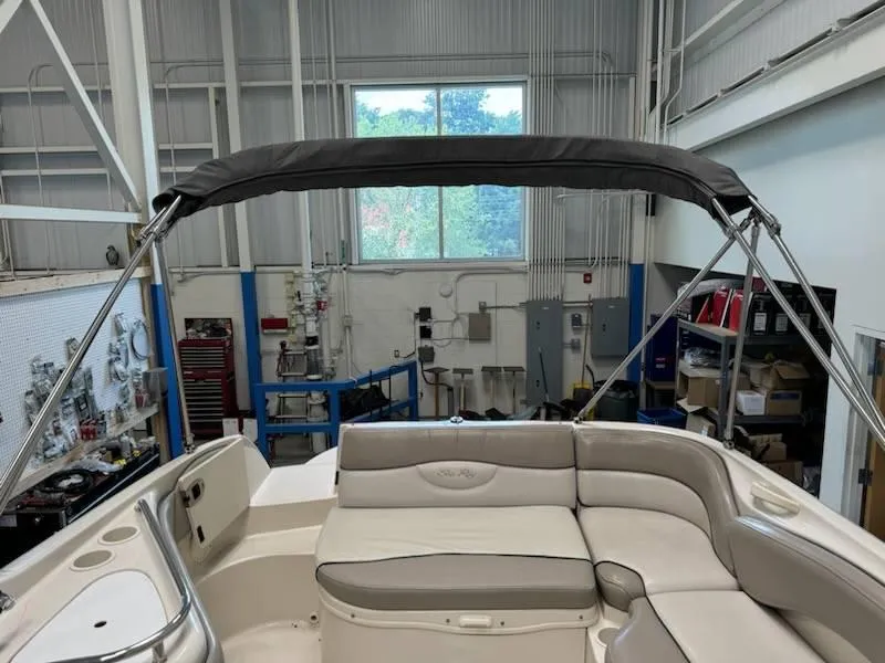 Slide: The Image of 2004 Sea Ray 240 Sundeck boat interior with bimini top in a workshop. - 6