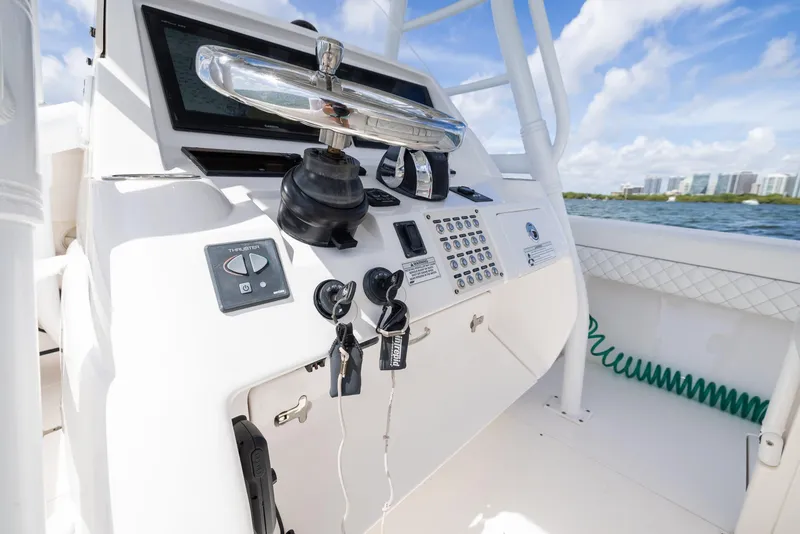 Slide: The Image of 2019 Intrepid 327 Center Console boat dashboard with controls and ocean view. - 10