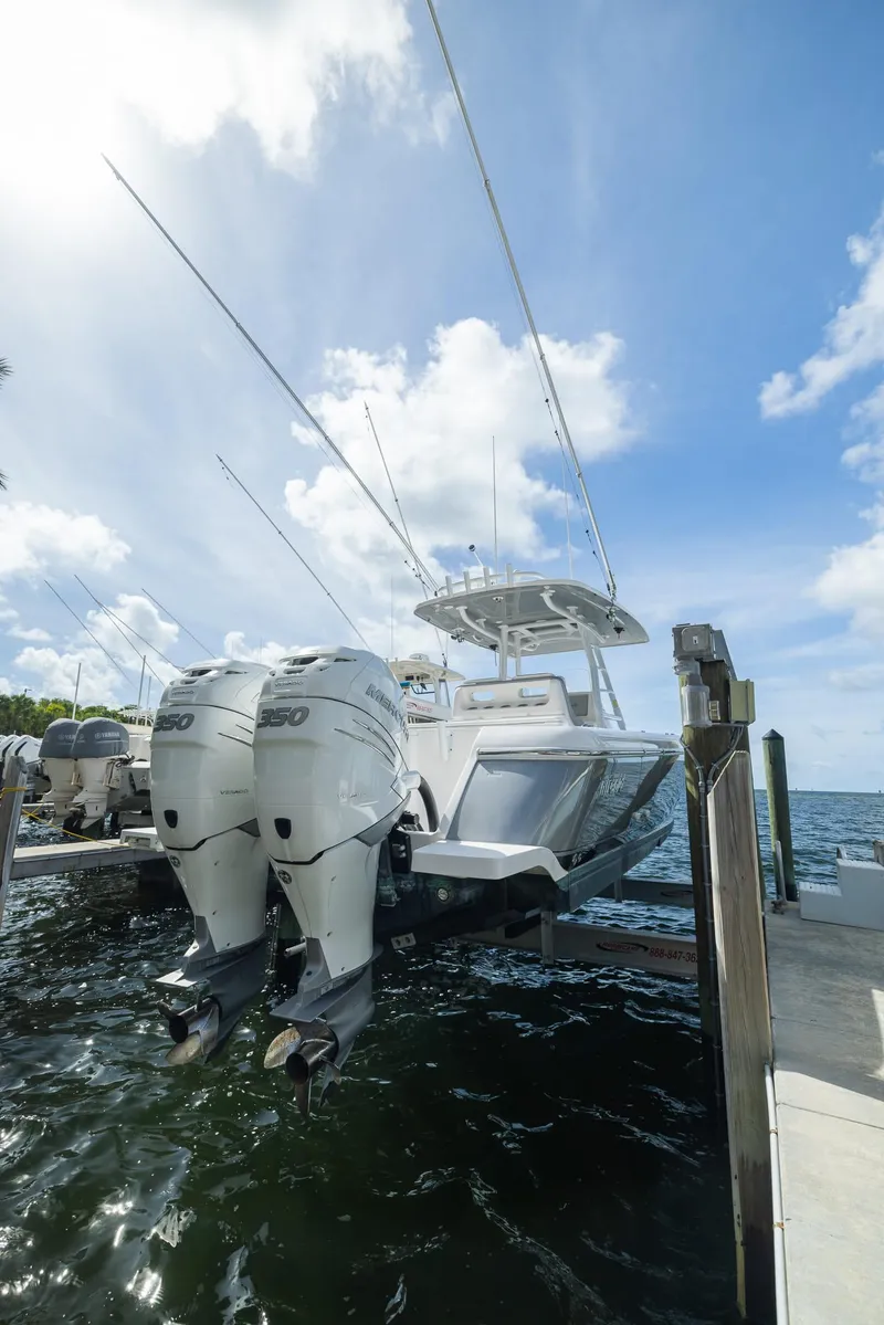 Slide: The Image of 2019 Intrepid 327 Center Console boat docked with twin outboard engines. - 18