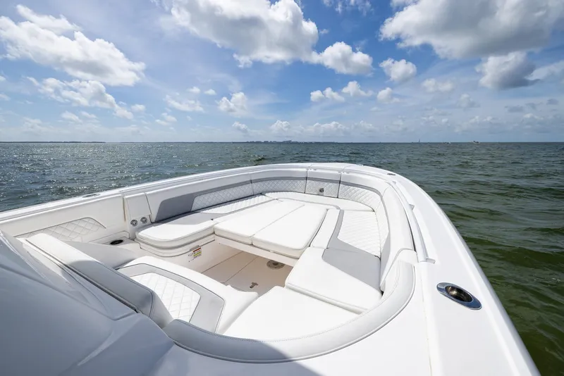 Slide: The Image of 2019 Intrepid 327 Center Console boat on open water under a partly cloudy sky. - 19