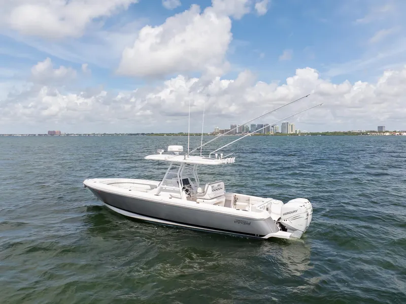 Slide: The Image of 2019 Intrepid 327 Center Console boat on open water with city skyline in background. - 21