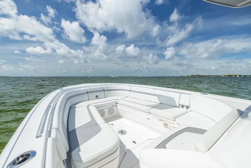 Slide: The Image of 2019 Intrepid 327 Center Console boat with white seating, ocean view, and blue sky. - 27