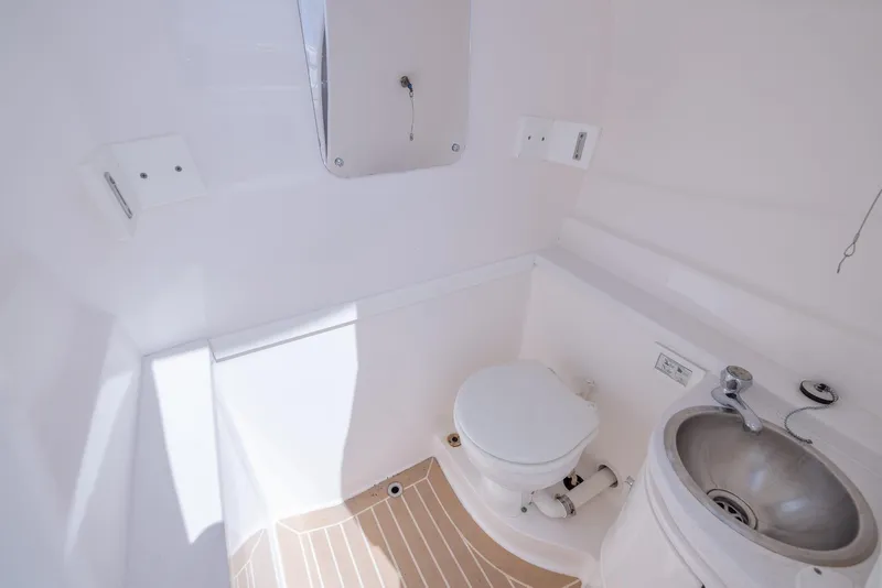 Slide: The Image of 2019 Intrepid 327 Center Console boat bathroom with toilet and sink. - 29