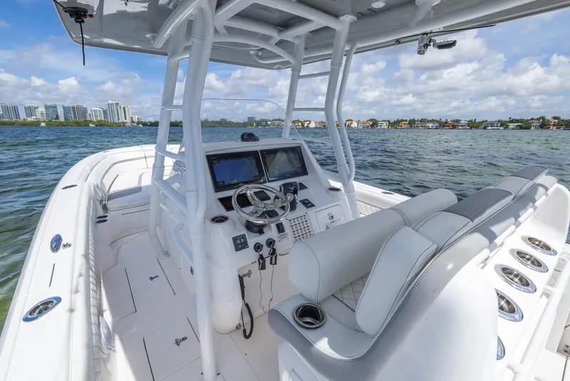 Slide: The Image of 2019 Intrepid 327 Center Console boat on water with modern dashboard and seating. - 30
