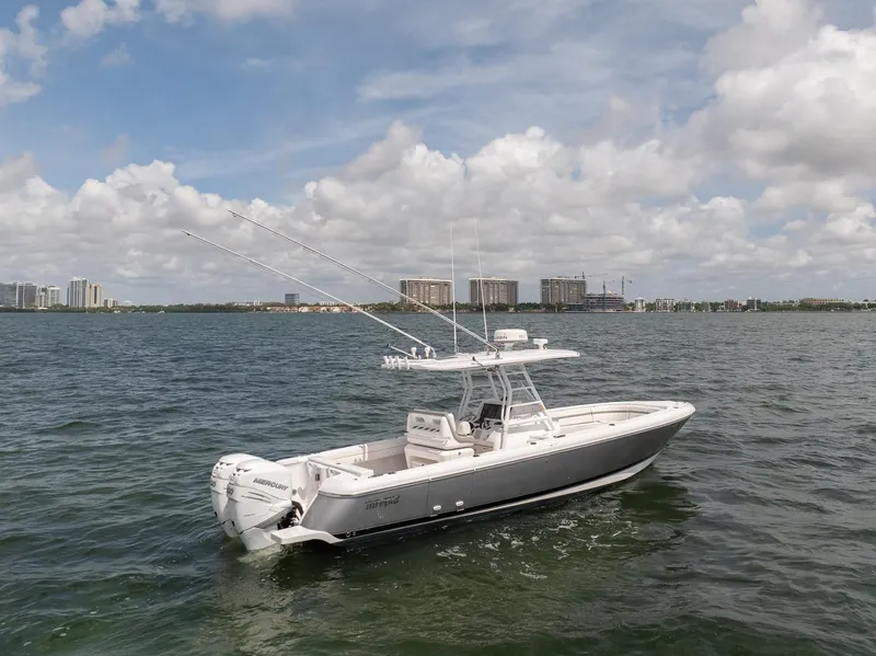 Slide: The Image of 2019 Intrepid 327 Center Console boat on open water with cityscape background. - 35