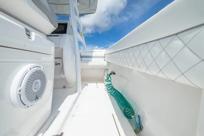 Slide: The Image of 2019 Intrepid 327 Center Console boat interior with coiled green hose and speaker. - 38