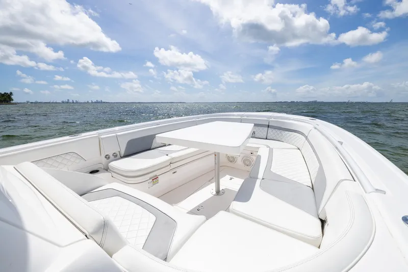 Slide: The Image of 2019 Intrepid 327 Center Console boat with white seating and table on open water. - 39