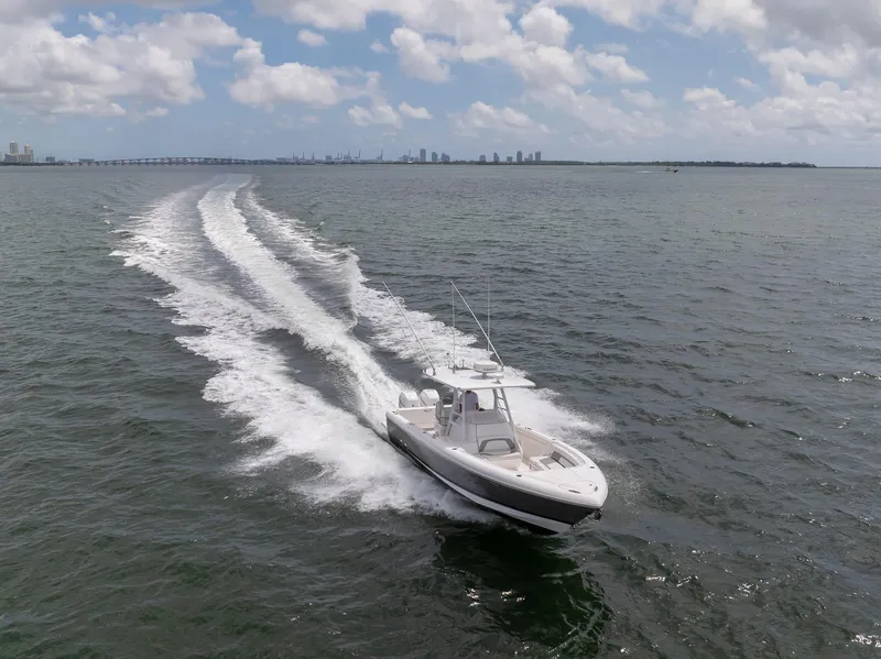 Slide: The Image of 2019 Intrepid 327 Center Console boat cruising on open water with city skyline in background. - 4