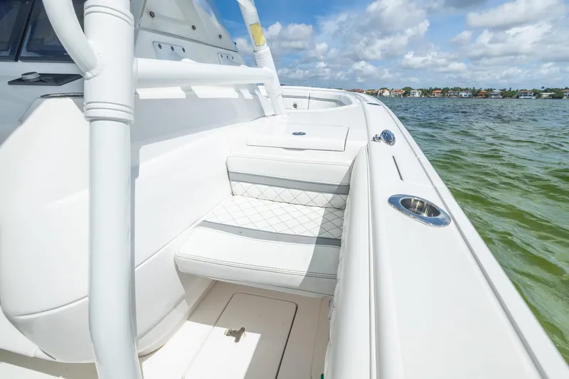 Slide: The Image of 2019 Intrepid 327 Center Console boat interior with white seating and ocean view. - 40