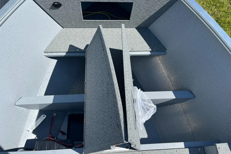 Slide: The Image of 2025 Lund 1600 Fury Tiller boat interior with storage compartments and wiring. - 10