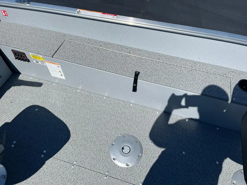 Slide: The Image of 2025 Lund 1600 Fury Tiller boat interior with gray flooring and storage compartments. - 14