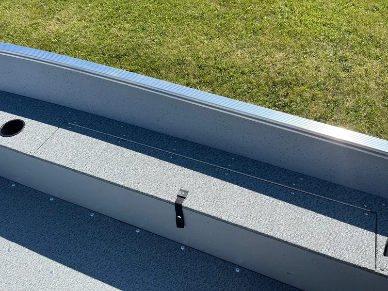 Slide: The Image of 2025 Lund 1600 Fury Tiller boat interior with storage compartment and rod holder. - 15