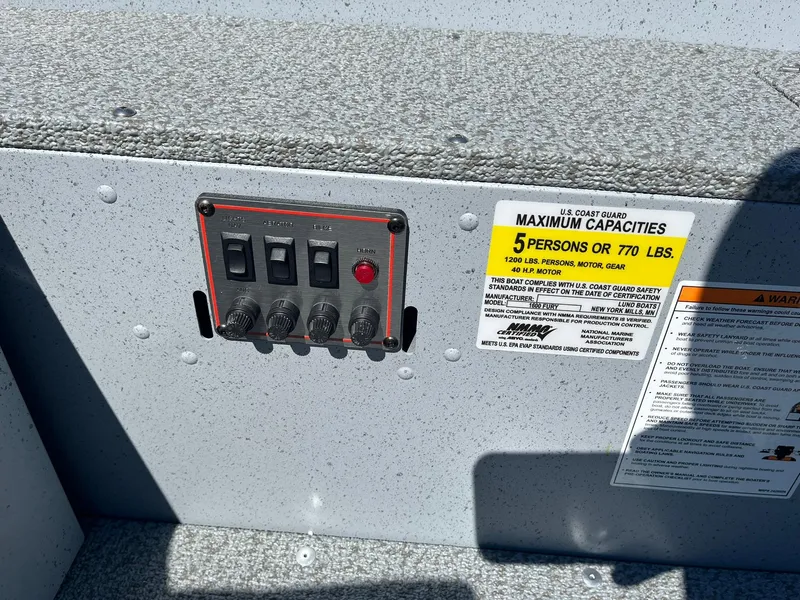 Slide: The Image of Control panel and capacity label on a 2025 Lund 1600 Fury Tiller boat. - 19