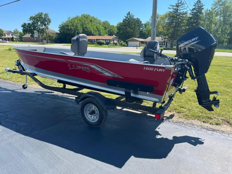 Slide: The Image of 2025 Lund 1600 Fury Tiller boat on trailer with Mercury outboard motor. - 3