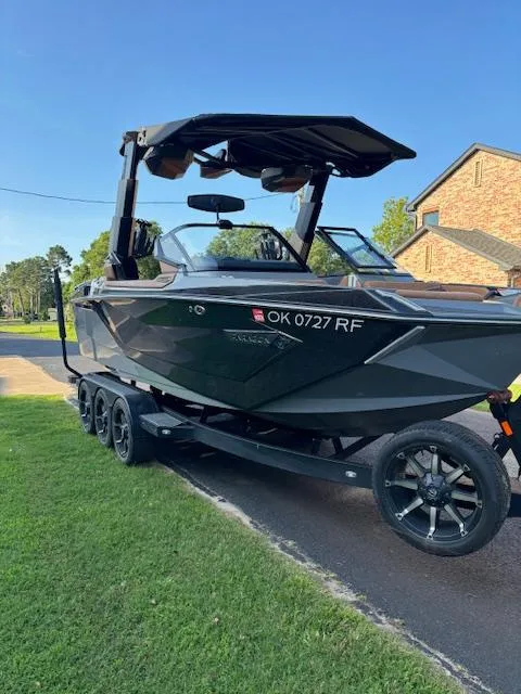 Slide: The Image of 2020 Nautique P23 boat on a trailer in a residential area. - 10