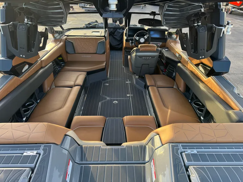 Slide: The Image of 2020 Nautique P23 boat interior with brown leather seating and advanced audio system. - 2