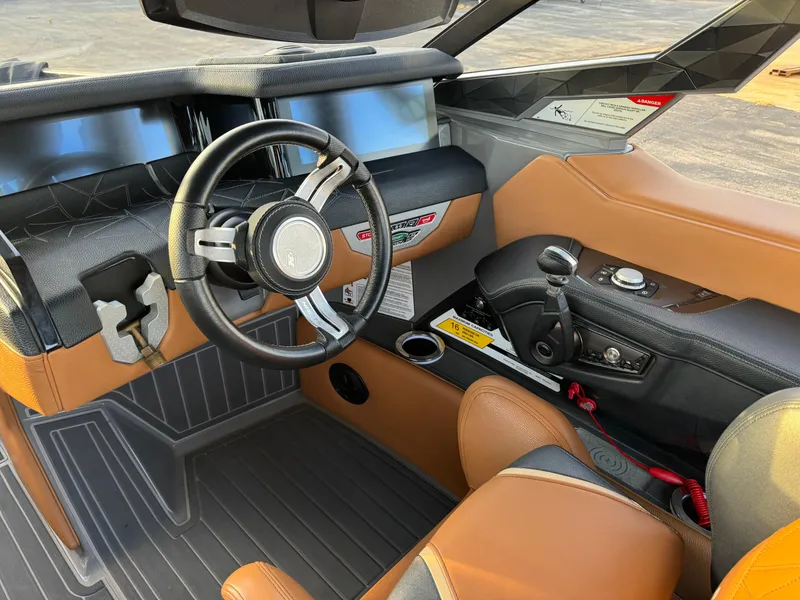 Slide: The Image of 2020 Nautique P23 boat interior with sleek steering wheel and modern dashboard design. - 4