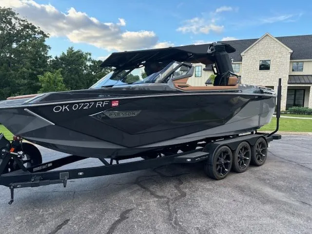Slide: The Image of 2020 Nautique P23 boat on a trailer in a residential driveway. - 7