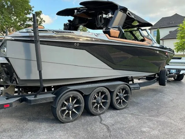 Slide: The Image of 2020 Nautique P23 boat on a trailer, sleek black and gray design. - 9