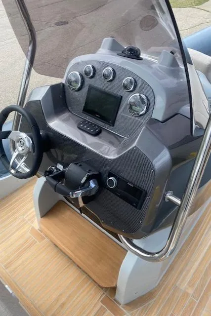 Slide: The Image of 2024 SACS Strider 900 boat dashboard with steering wheel and control panel. - 3