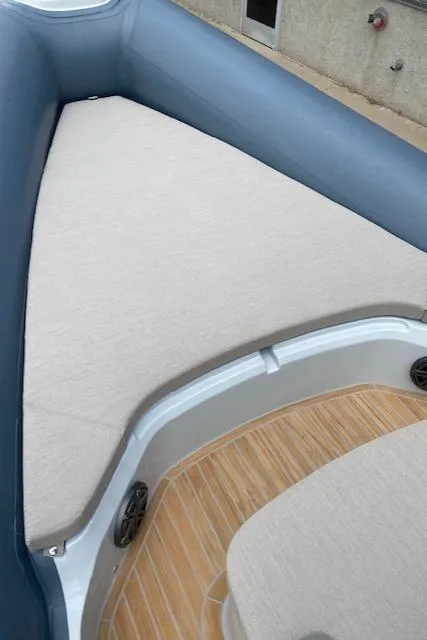 Slide: The Image of 2024 SACS Strider 900 boat interior with cushioned seating and teak flooring. - 9