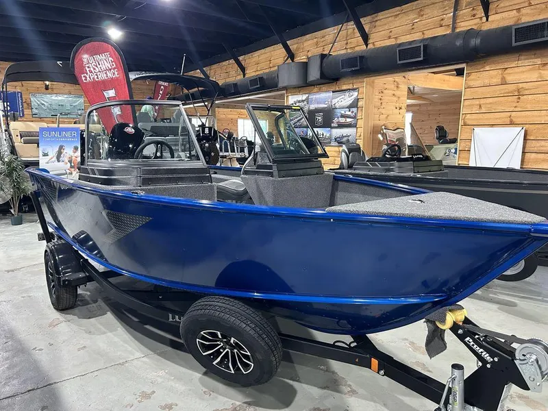 Slide: The Image of 2025 Lund Adventure 1775 Sport boat in showroom, blue exterior, on trailer. - 5