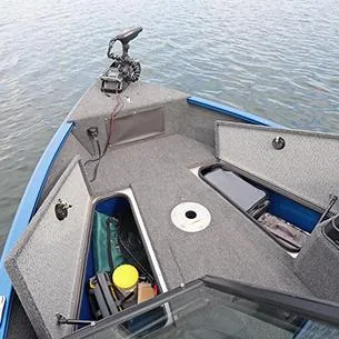 Slide: The Image of 2025 Lund Adventure 1775 Sport boat interior with open storage compartments on calm water. - 11