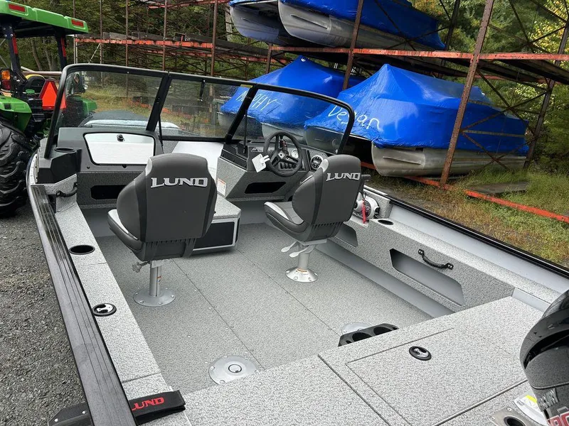 Slide: The Image of 2025 Lund Adventure 1775 Sport boat with dual seats and windshield, parked outdoors. - 5