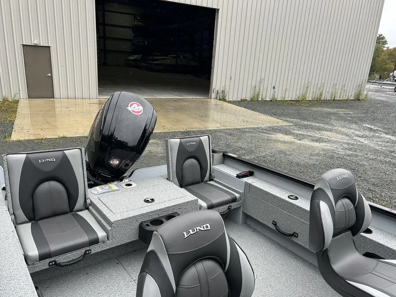 Slide: The Image of 2025 Lund Adventure 1775 Sport boat with seating, parked outside a warehouse. - 6