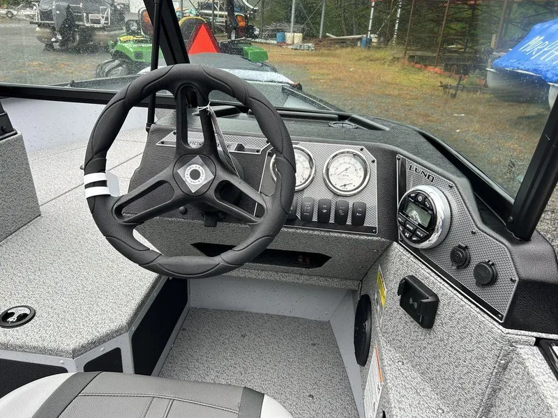 Slide: The Image of 2025 Lund Adventure 1775 Sport boat dashboard with steering wheel and gauges. - 7