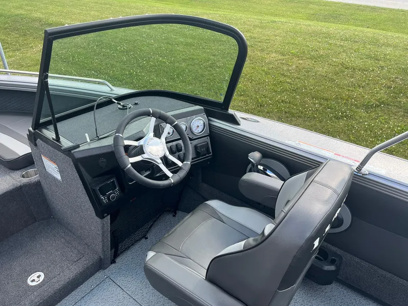Slide: The Image of Interior of 2025 Lund 1975 Tyee boat with steering wheel and captain's chair. - 13